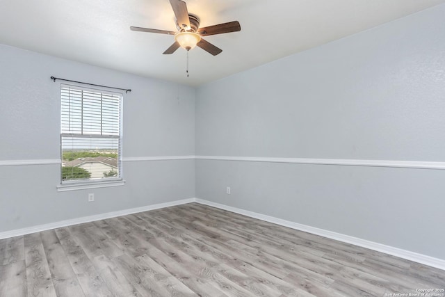empty room with baseboards, ceiling fan, and light wood-style floors