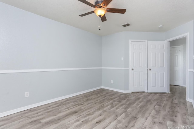 unfurnished bedroom with a closet, visible vents, light wood finished floors, and baseboards