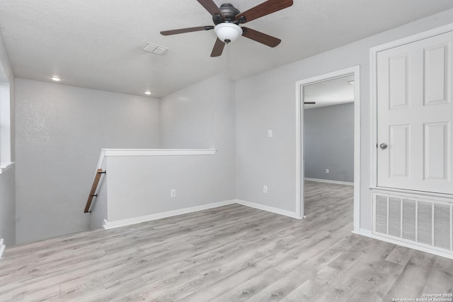interior space with baseboards, wood finished floors, visible vents, and ceiling fan