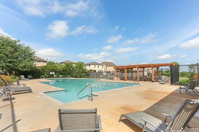 pool with a patio area and fence