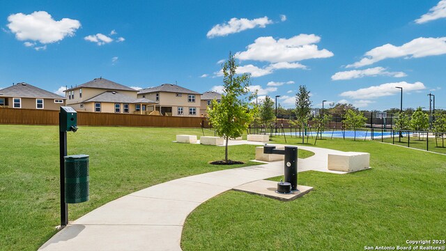 view of property's community with fence and a yard