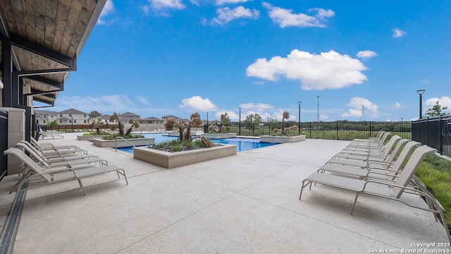 community pool featuring fence and a patio area