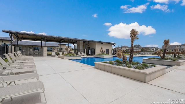 community pool with fence, a residential view, and a patio