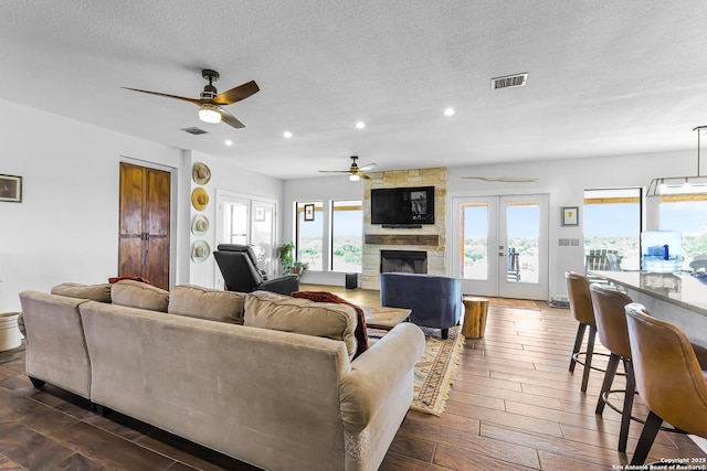 living room with recessed lighting, visible vents, ceiling fan, and a fireplace
