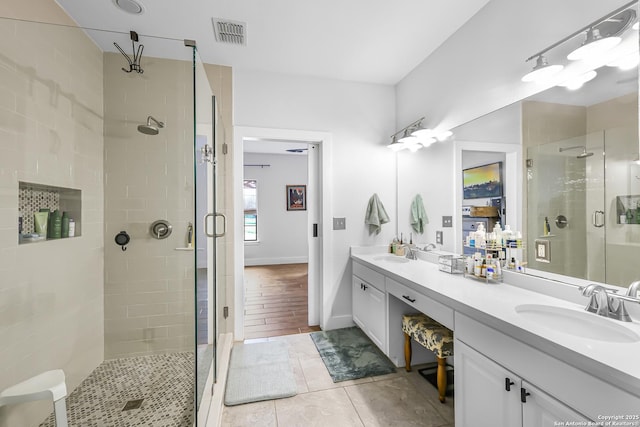 bathroom with double vanity, a sink, visible vents, and a stall shower