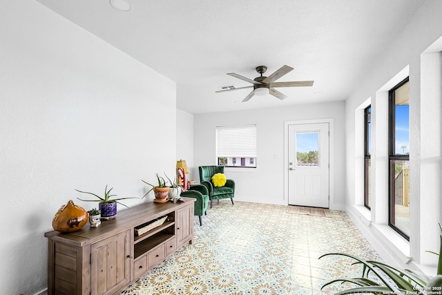 entryway featuring light floors, ceiling fan, and baseboards