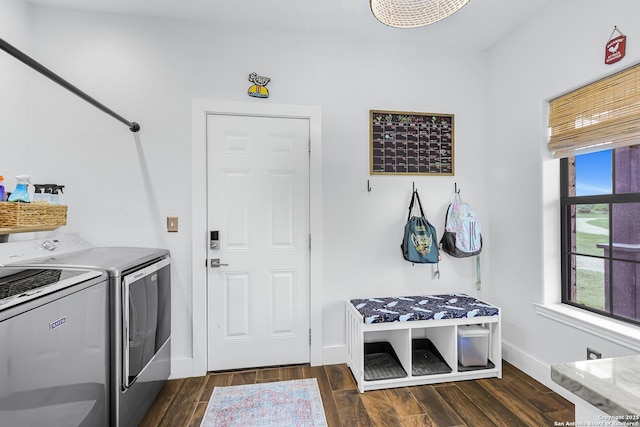 washroom featuring washing machine and dryer, dark wood-type flooring, baseboards, and laundry area