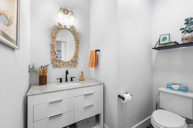 half bath featuring vanity and toilet
