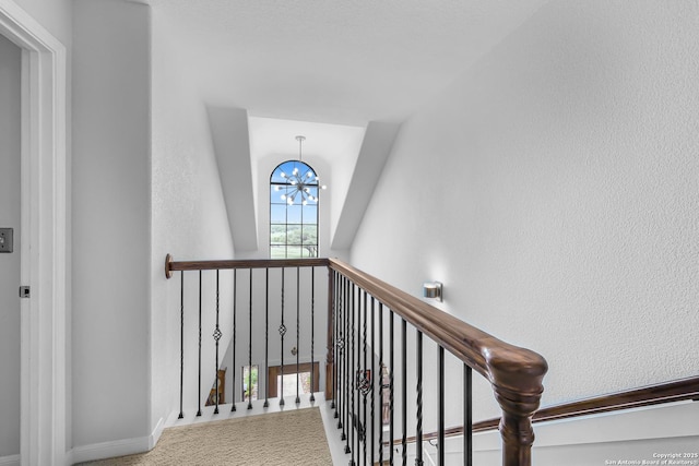 stairs featuring baseboards and an inviting chandelier