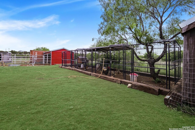 view of yard featuring fence, exterior structure, and an outdoor structure