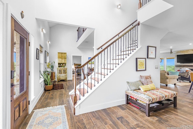 entryway with baseboards, a towering ceiling, recessed lighting, wood finished floors, and stairway