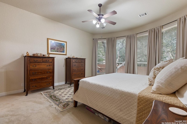 bedroom with visible vents, light carpet, baseboards, and multiple windows