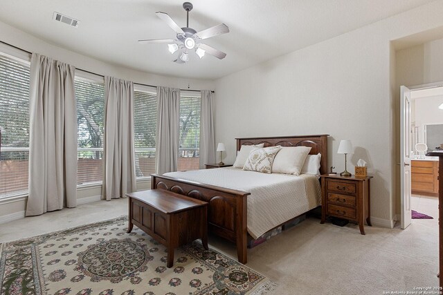 bedroom featuring visible vents, light colored carpet, and multiple windows