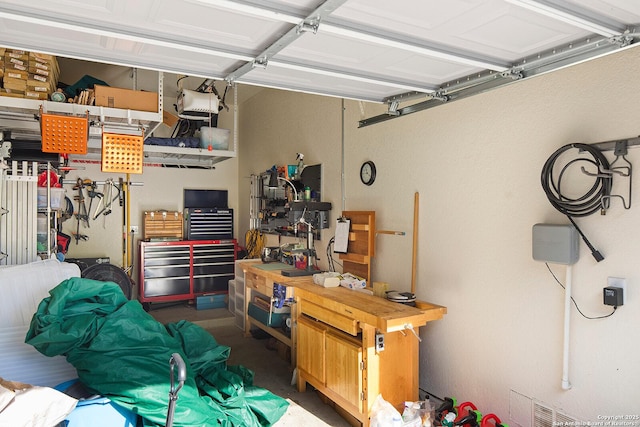 garage with a workshop area and a garage door opener
