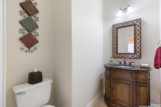 half bath with baseboards, toilet, and vanity