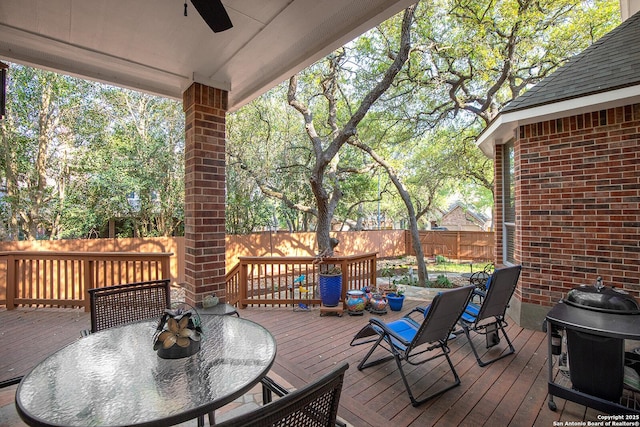 deck featuring area for grilling, a fenced backyard, a ceiling fan, and outdoor dining space