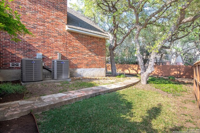 view of yard with fence and central air condition unit