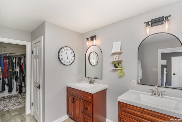 21707 Beaver Bnd, San Antonio, TX 78258 - bathroom with two vanities, baseboards, a sink, and a spacious closet