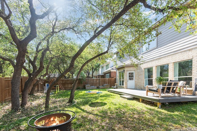 21707 Beaver Bnd, San Antonio, TX 78258 - view of yard featuring a fenced backyard, a wooden deck, and an outdoor fire pit