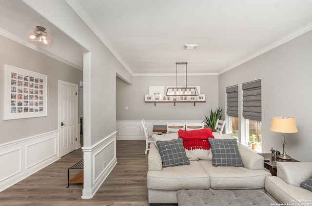 21707 Beaver Bnd, San Antonio, TX 78258 - living room with dark wood-style floors, crown molding, a wainscoted wall, a notable chandelier, and visible vents