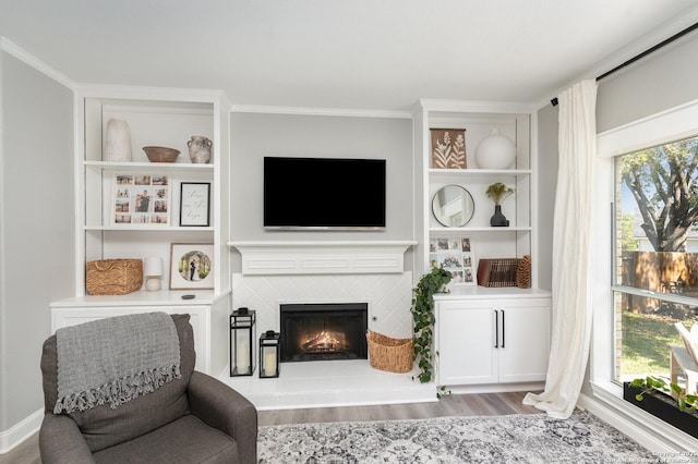 21707 Beaver Bnd, San Antonio, TX 78258 - living area with built in features, wood finished floors, and a tiled fireplace