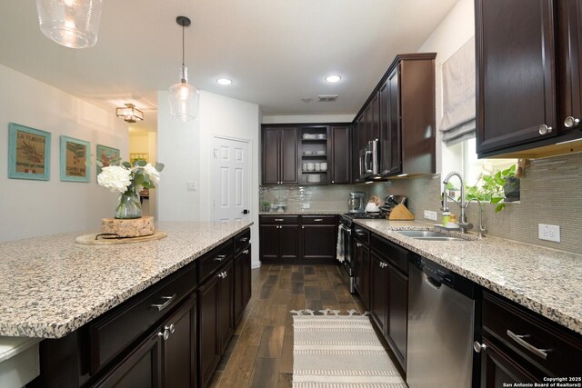 kitchen featuring light stone counters, tasteful backsplash, stainless steel appliances, and a sink