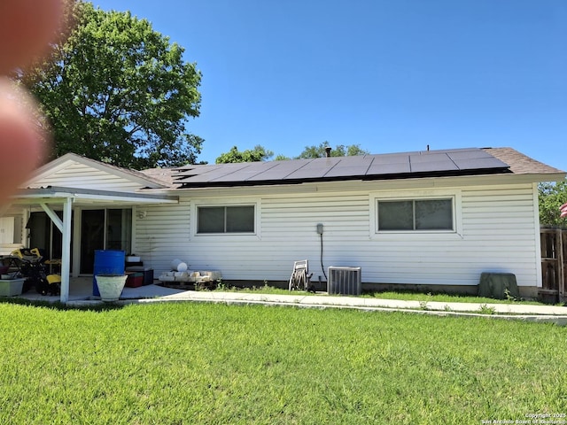 7722 Village Oaks Dr, Live Oak, TX 78233 - rear view of property with roof mounted solar panels, a lawn, and central air condition unit