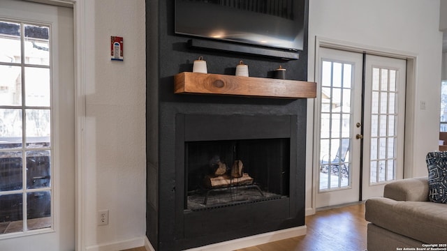 living room with baseboards, wood finished floors, and a fireplace