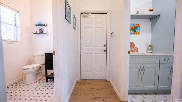 interior space featuring baseboards, a sink, and light floors