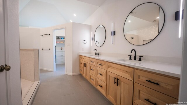 full bath featuring lofted ceiling, tile patterned flooring, a sink, and double vanity