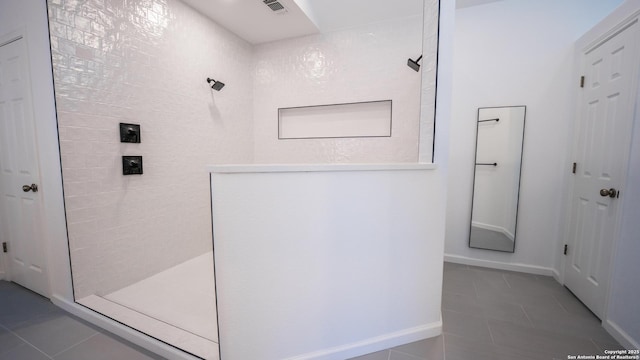 full bathroom with baseboards, walk in shower, tile patterned flooring, and visible vents