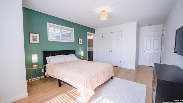 bedroom with baseboards, light wood-style floors, and a closet