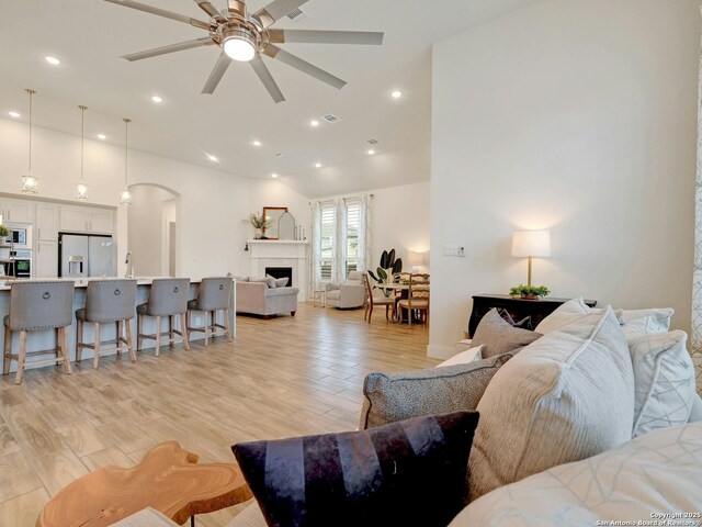 24742 Para Siempre, San Antonio, TX 78261 - living room featuring a ceiling fan, arched walkways, a fireplace, recessed lighting, and light wood-style flooring