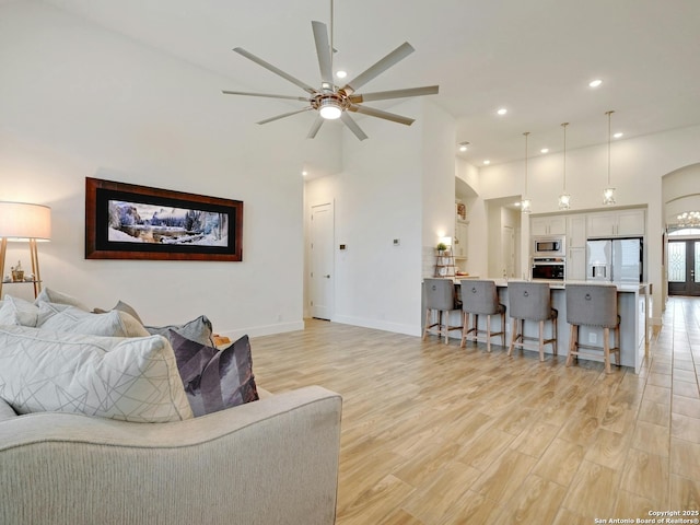 24742 Para Siempre, San Antonio, TX 78261 - living room with light wood finished floors, a ceiling fan, baseboards, recessed lighting, and a towering ceiling