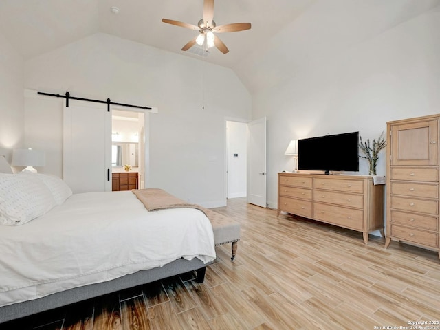 24742 Para Siempre, San Antonio, TX 78261 - bedroom with connected bathroom, ceiling fan, a barn door, light wood finished floors, and high vaulted ceiling