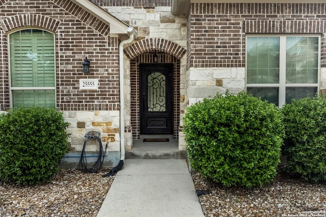 doorway to property featuring brick siding and stone siding