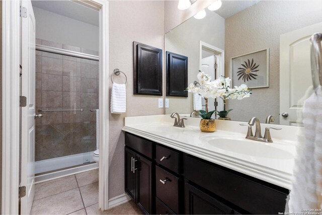 full bath with a shower stall, toilet, tile patterned flooring, and a sink