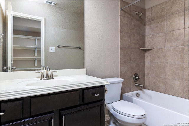 full bathroom featuring a textured wall, visible vents, toilet, vanity, and shower / tub combination