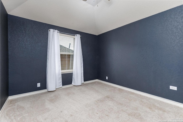 unfurnished room with lofted ceiling, carpet, a ceiling fan, and baseboards
