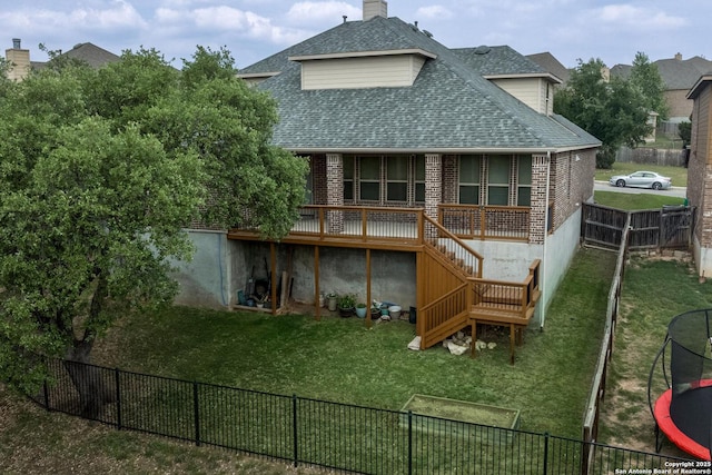 rear view of house with a fenced backyard, a lawn, a shingled roof, and brick siding