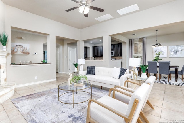 living room with light tile patterned flooring, visible vents, a ceiling fan, and baseboards
