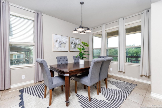 dining room with a chandelier, a wealth of natural light, baseboards, and light tile patterned flooring