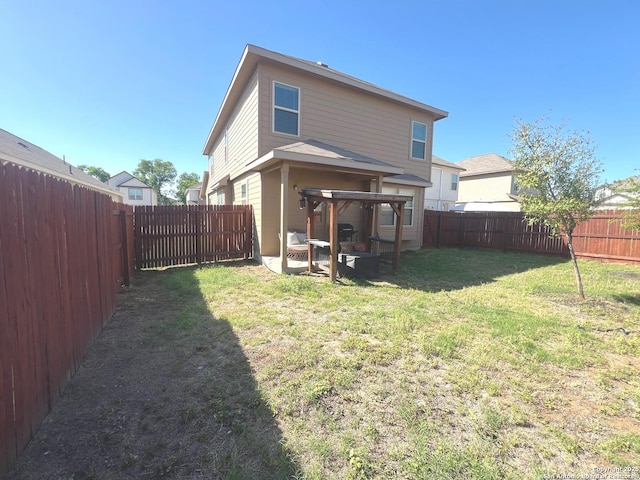 rear view of house featuring a fenced backyard, a gazebo, and a yard
