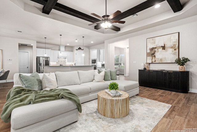 living area with recessed lighting, light wood-style floors, and beamed ceiling