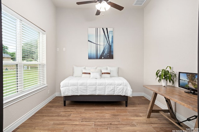 bedroom with light wood-type flooring, visible vents, baseboards, and ceiling fan