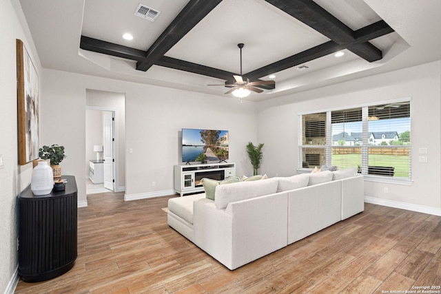 living area with light wood finished floors, coffered ceiling, visible vents, baseboards, and ceiling fan