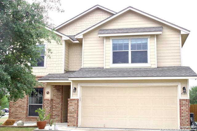craftsman-style home featuring an attached garage, a shingled roof, brick siding, and concrete driveway
