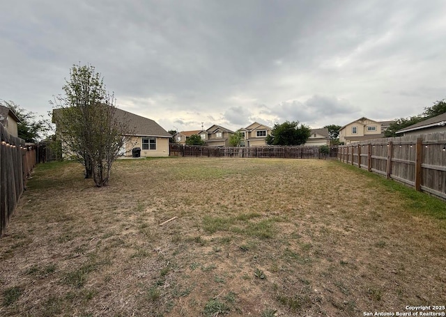 view of yard featuring a residential view and a fenced backyard