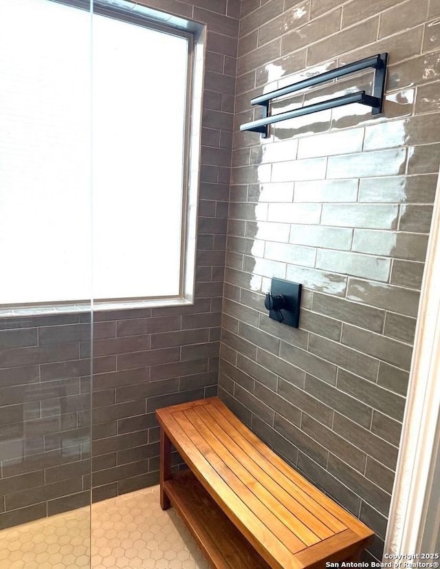 full bathroom with a tile shower and a healthy amount of sunlight