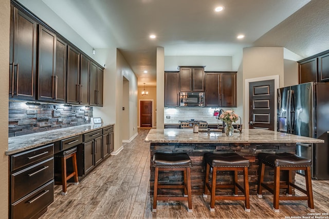 12177 Tower Frst, San Antonio, TX 78253 - kitchen featuring light stone countertops, stainless steel microwave, fridge with ice dispenser, and tasteful backsplash